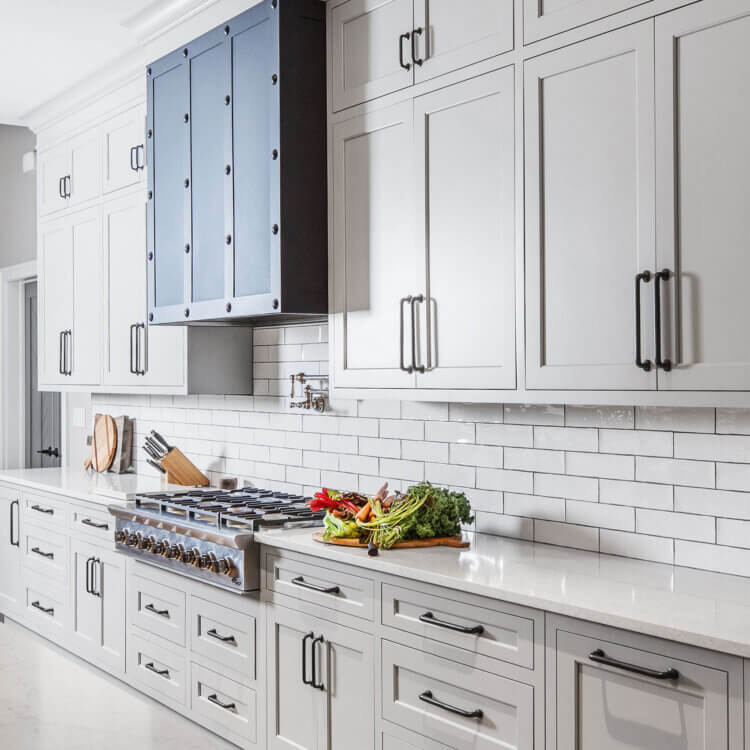 An all white modern farmhouse style kitchen design with white painted shaker cabinets.