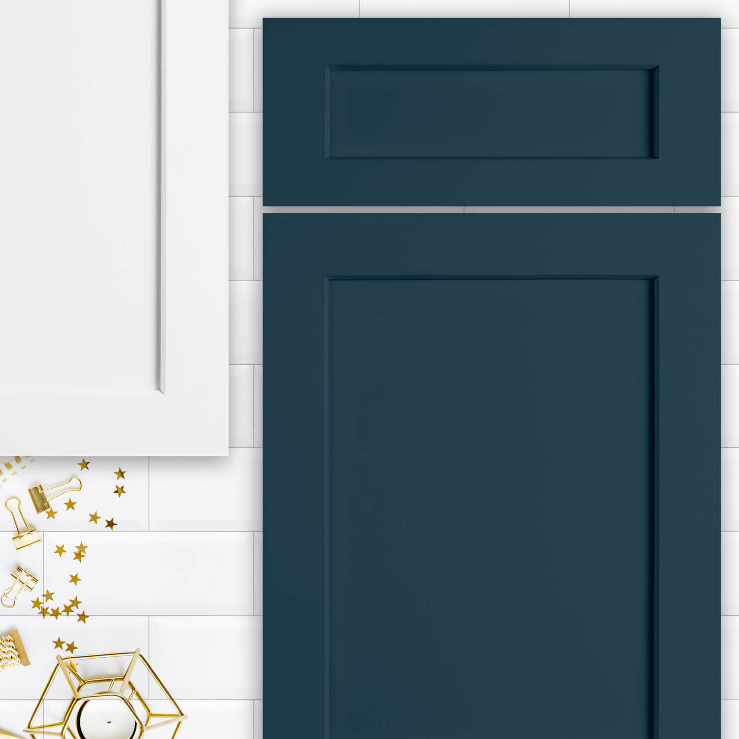 A mood board with two shaker door styles lying on white subway tile. One cabinet door is painted navy blue and the other white.