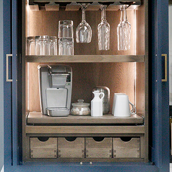 Interior cabinet lighting in a larder cabinet with customized storage.