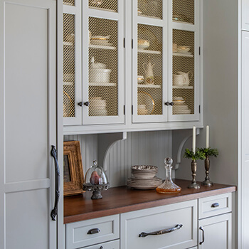 Instead of glass, these accent cabinet doors feature satin brass wired mesh inserts in the cabinet doors.