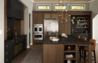 A pretty kitchen remodel with a stained wood cabinets in two tones of black and medium brown.