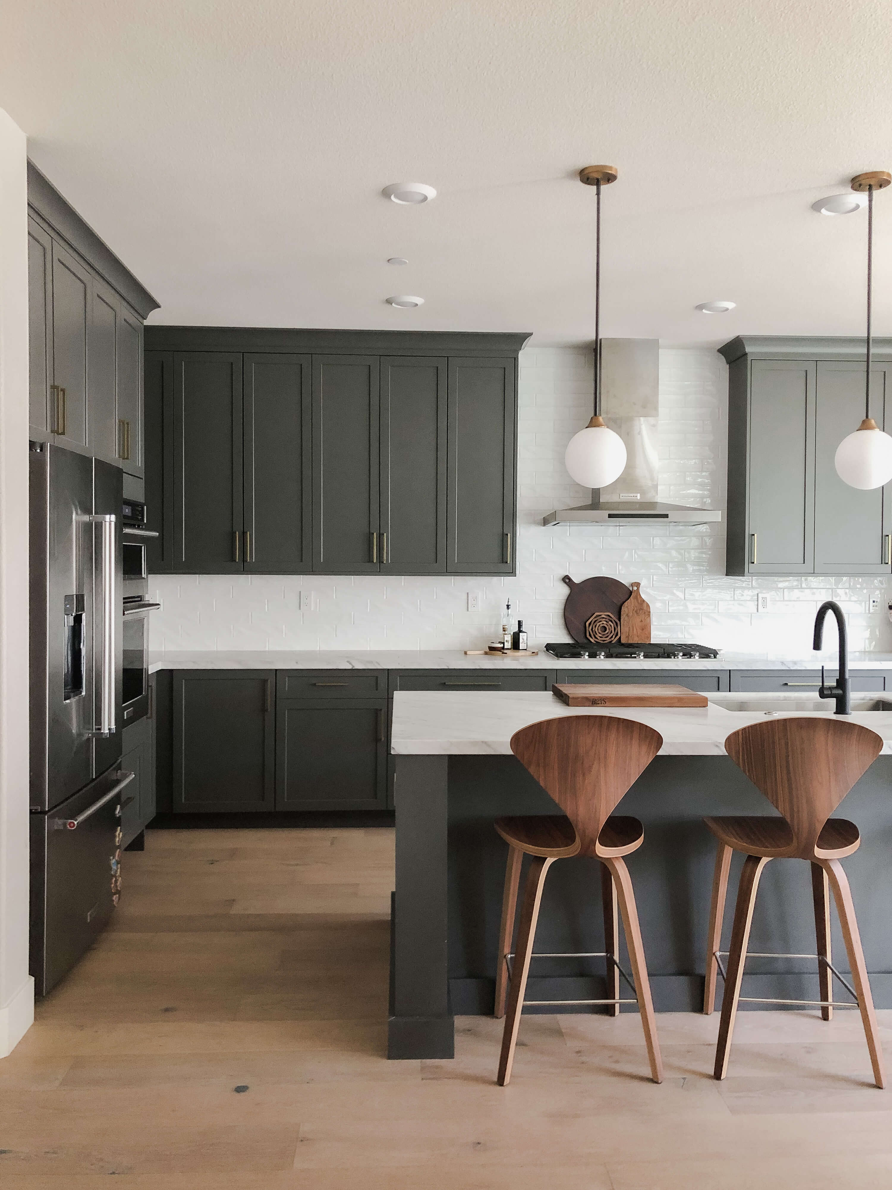 A dark and moody kitchen remodel with deep green painted cabinets from Dura Supreme.