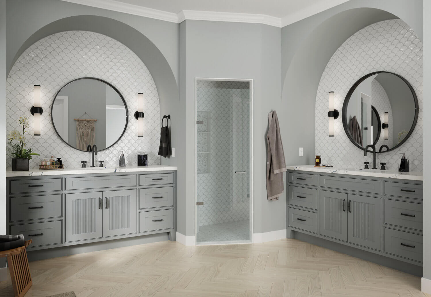 Double vanities in a large master bathroom with arched insets into the wall with gray paint and reeded cabinet doors.