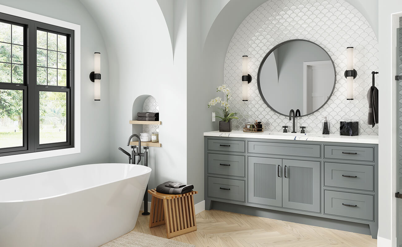 A boho inspired master bathroom with a gray painted vanity with reeded cabinet doors.
