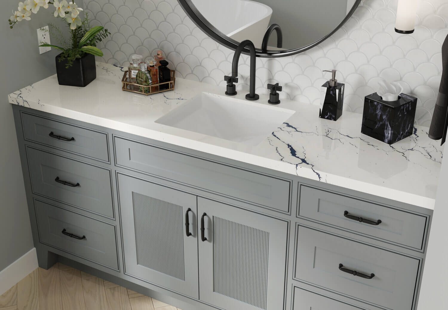 A close up of a gray vanity with reeded details on the doors and black hardware accents.