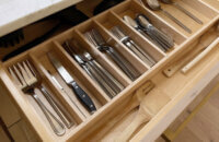 A wide kitchen drawer with organized and divided utensil and silverware storage.