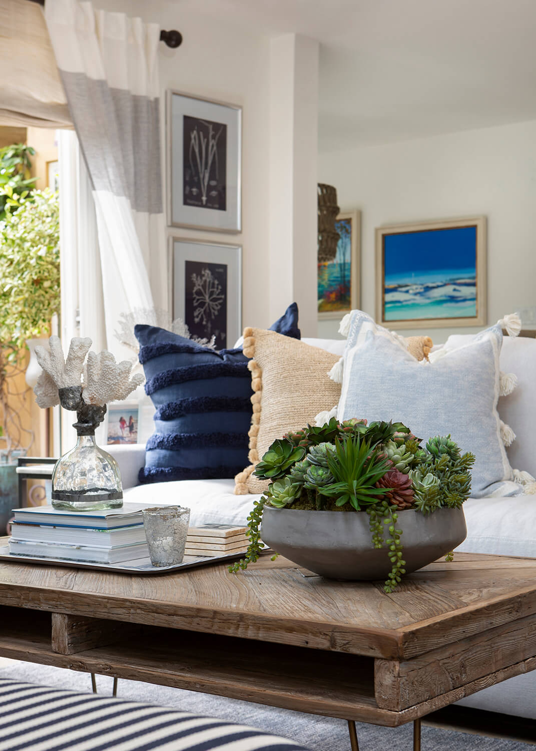 A Coastal style living room with driftwood accents, throw pillows, and, nautical details.