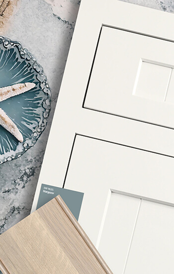 A Coastal design concept flat lay with nautical decor, and white shaker door style with shiplap details.