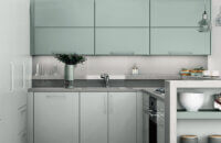 A contemporary white and light mint green kitchen design with minimalistic slab door styles with an ultra matte finish.