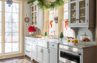 The modern old English style butler's pantry with light gray painted cabinets from Dura Supreme is decorated for Christmas.