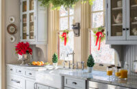 A Christmas kitchen design with an old English style featuring light gray painted cabinets from Dura Supreme Cabinetry.