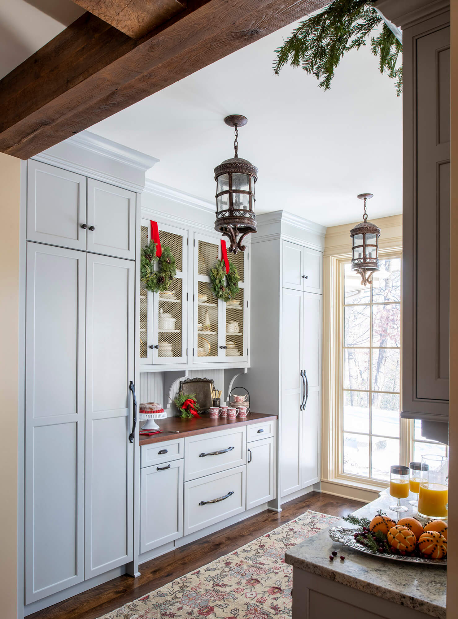 A festive butler's pantry design with Christmas decorations a light gray custom cabinets from Dura Supreme.
