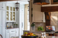 A traditional farmhouse kitchen with an old English styled butler's pantry side kitchen.