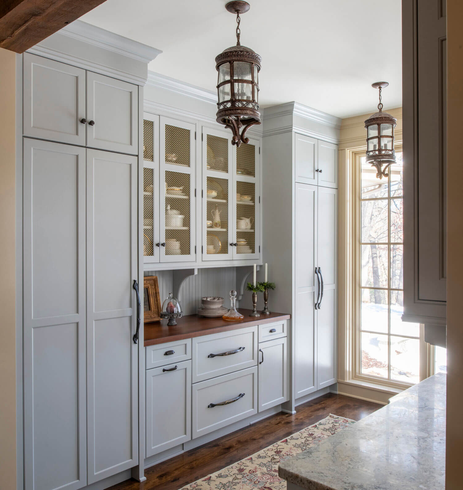 A new Old English style pantry with inset cabinet doors and a light gray painted finish from Dura Supreme Cabinetry.