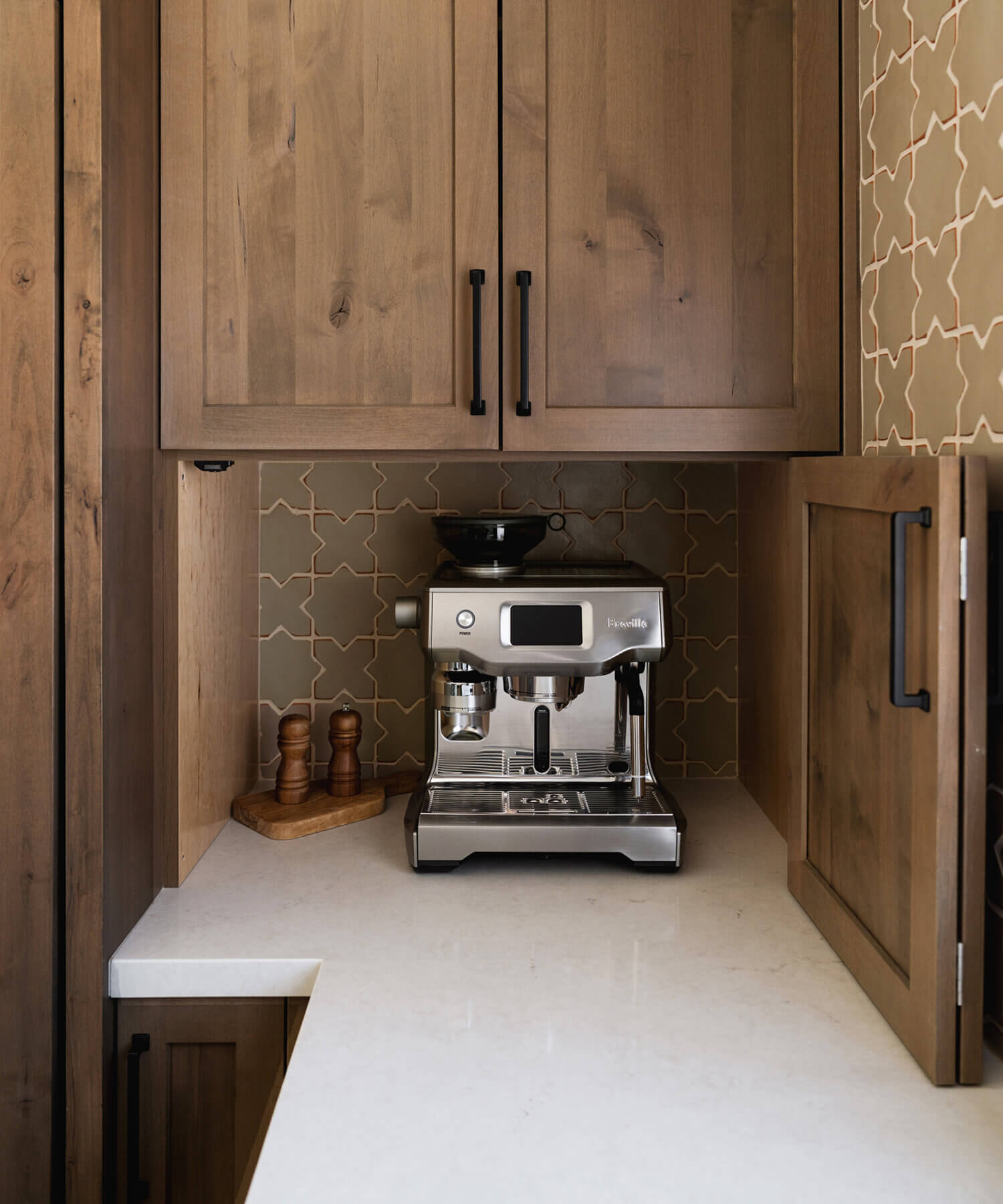 A larder cabinet in a corner at counter height with a hidden coffee station.