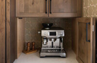 A larder cabinet in a corner at counter height with a hidden coffee station.