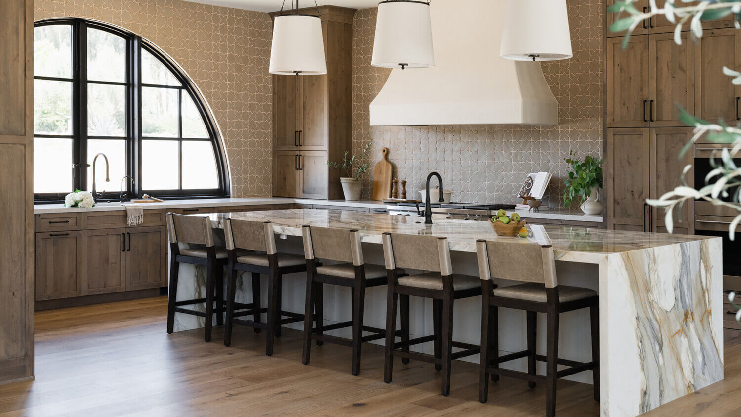 With an emphasis on comfort, heritage-inspired details, and lived-in textures, this family home is a Mediterranean oasis. This stunning Mediterranean inspired home features Dura Supreme’s Hudson shaker door style in a combination of the “Cashew” stain on Knotty Alder