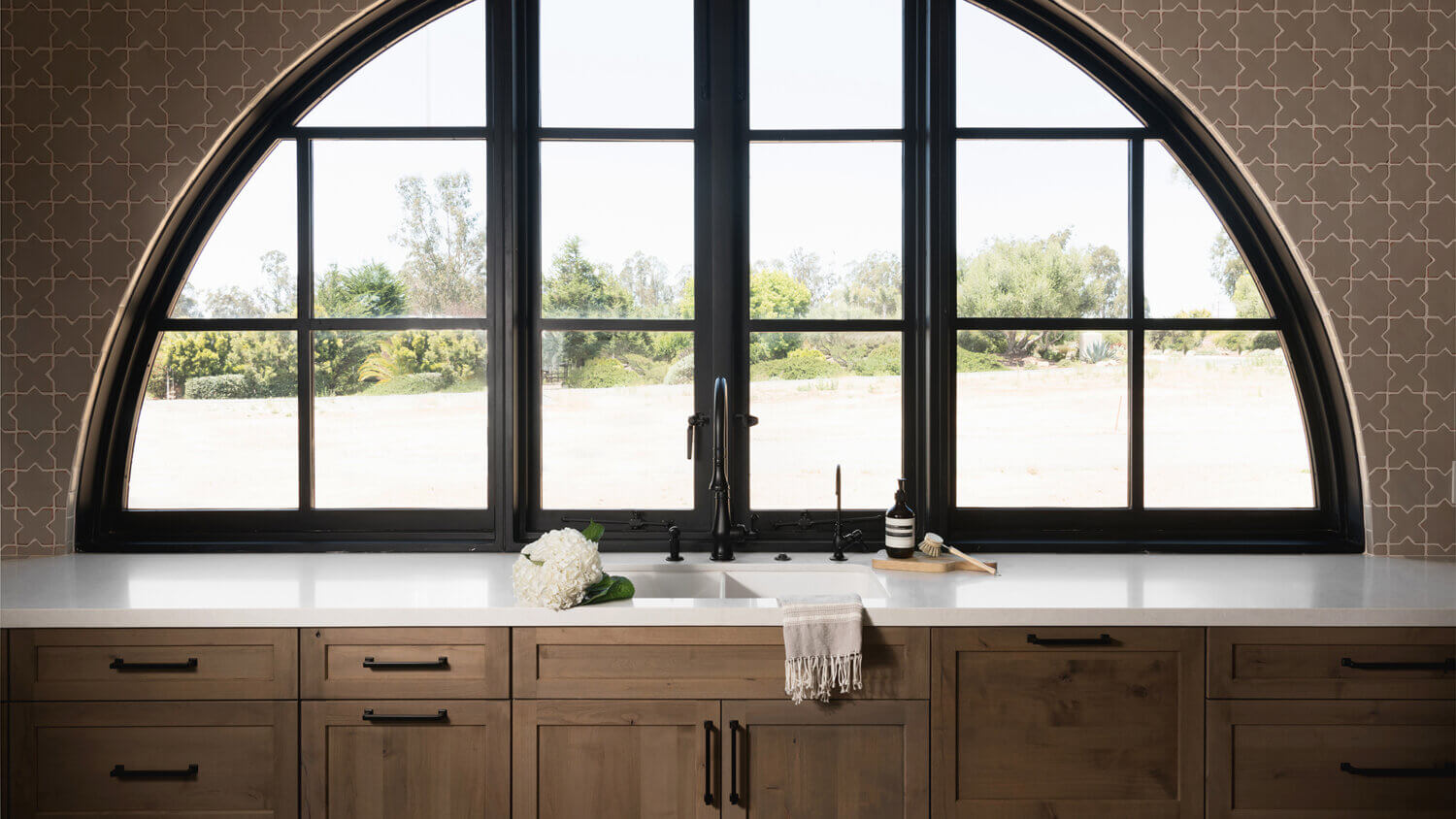 With an emphasis on comfort, heritage-inspired details, and lived-in textures, this family home is a Mediterranean oasis. This stunning Mediterranean inspired home features Dura Supreme’s Hudson shaker door style in a combination of the “Cashew” stain on Knotty Alder