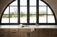 With an emphasis on comfort, heritage-inspired details, and lived-in textures, this family home is a Mediterranean oasis. This stunning Mediterranean inspired home features Dura Supreme’s Hudson shaker door style in a combination of the “Cashew” stain on Knotty Alder