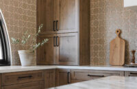 With an emphasis on comfort, heritage-inspired details, and lived-in textures, this family home is a Mediterranean oasis. This stunning Mediterranean inspired home features Dura Supreme’s Hudson shaker door style in a combination of the “Cashew” stain on Knotty Alder