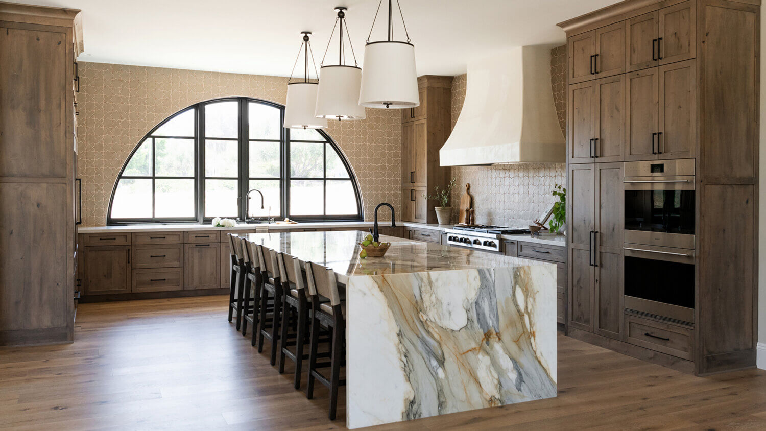 With an emphasis on comfort, heritage-inspired details, and lived-in textures, this family home is a Mediterranean oasis. This stunning Mediterranean inspired home features Dura Supreme’s Hudson shaker door style in a combination of the “Cashew” stain on Knotty Alder