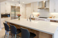 Modern, crisp paint finishes collide with natural, rustic, knotty alder in this transitional style kitchen remodel. The kitchen cabinets use Dura Supreme Cabinetry’s Hudson door style in Knotty Alder with a “Natural” finish for the kitchen island contrasted with the “Dove” paint for the perimeter.