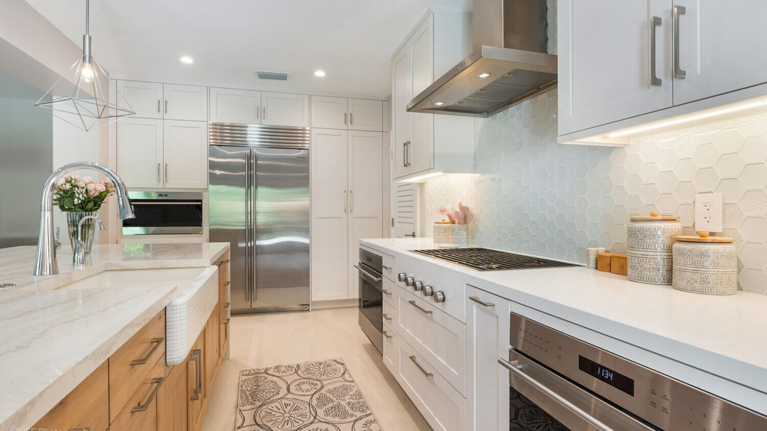 Modern, crisp paint finishes collide with natural, rustic, knotty alder in this transitional style kitchen remodel. The kitchen cabinets use Dura Supreme Cabinetry’s Hudson door style in Knotty Alder with a “Natural” finish for the kitchen island contrasted with the “Dove” paint for the perimeter.