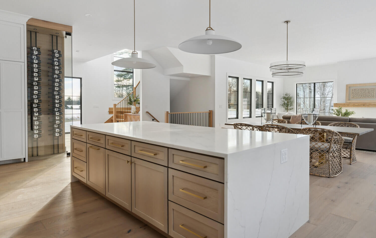 A view over the beautiful quarter-sawn white oak kitchen island with a light stained cabinet finish and white quartz countertops with waterfall ends.