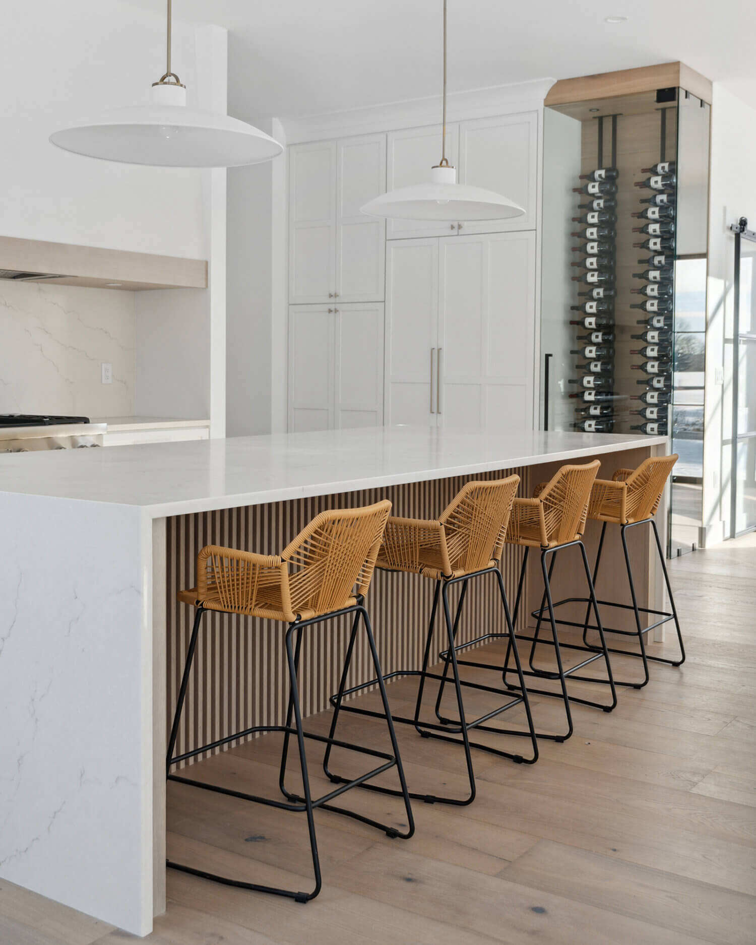 A waterfall kitchen island with seating for 4 featuring light stained oak with custom fluted texture.