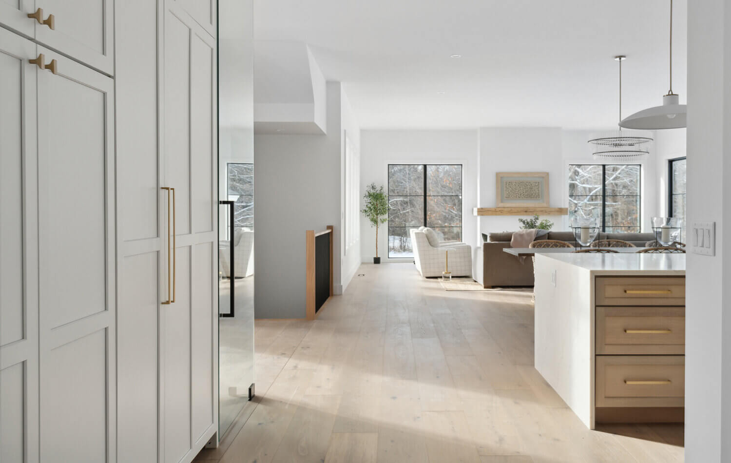 A look through the hallway, into the kitchen and open living room space of a newly built modern farmhouse.