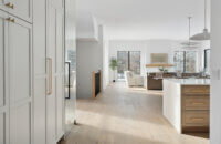 A look through the hallway, into the kitchen and open living room space of a newly built modern farmhouse.