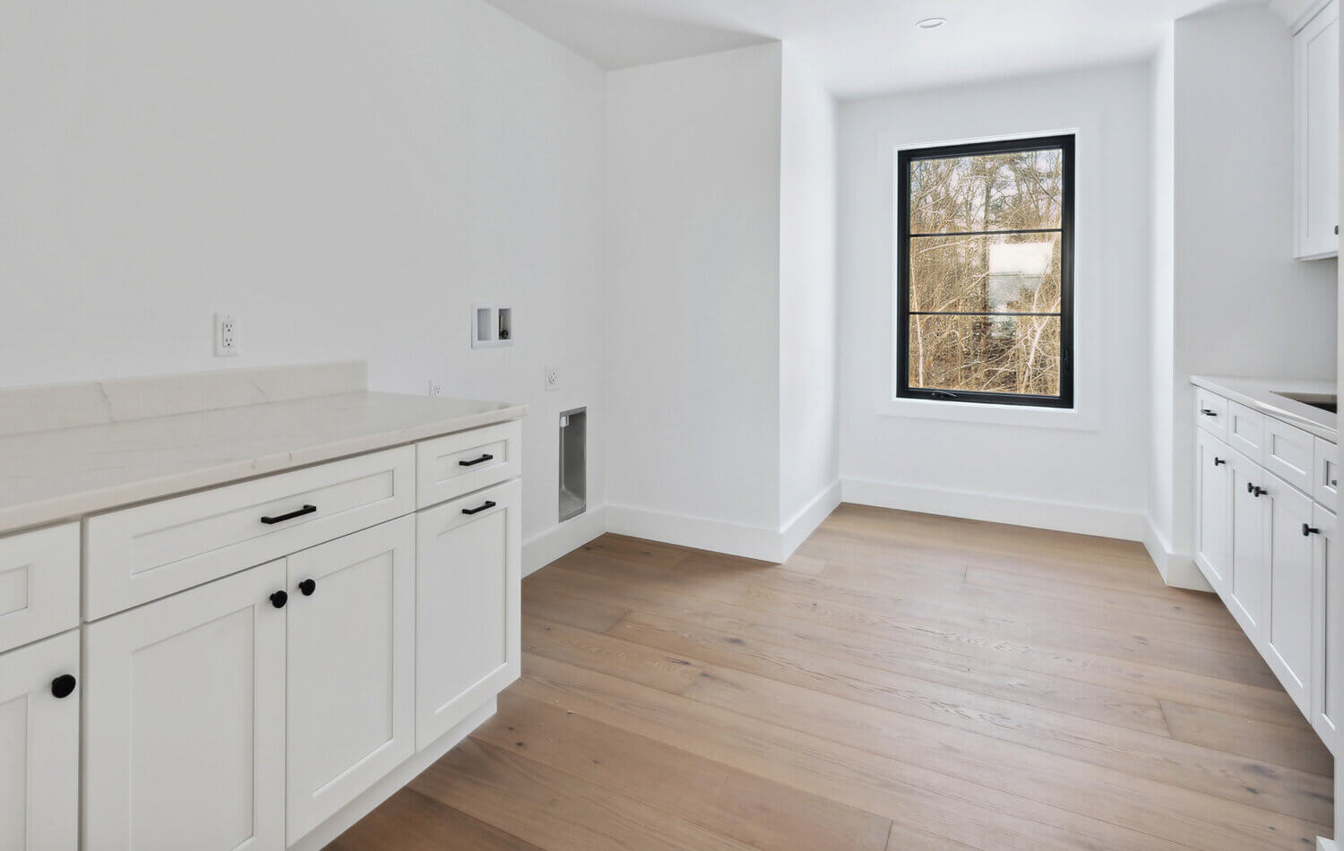 The all-white laundry room is ready for a new washer and dryer.