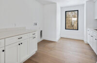 The all-white laundry room is ready for a new washer and dryer.