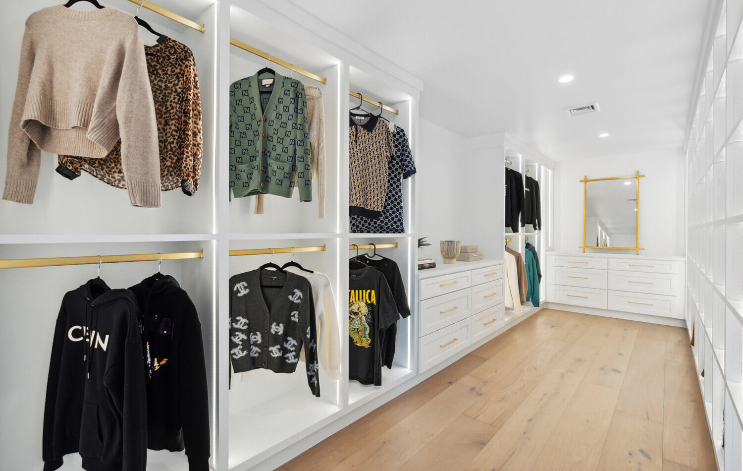 A luxury walk-in closet off the master bedroom with his and her storage. There are two layers of hanging rod storage, built-in dressers and dedicated space for both the husband and wife.