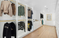 A luxury walk-in closet off the master bedroom with his and her storage. There are two layers of hanging rod storage, built-in dressers and dedicated space for both the husband and wife.