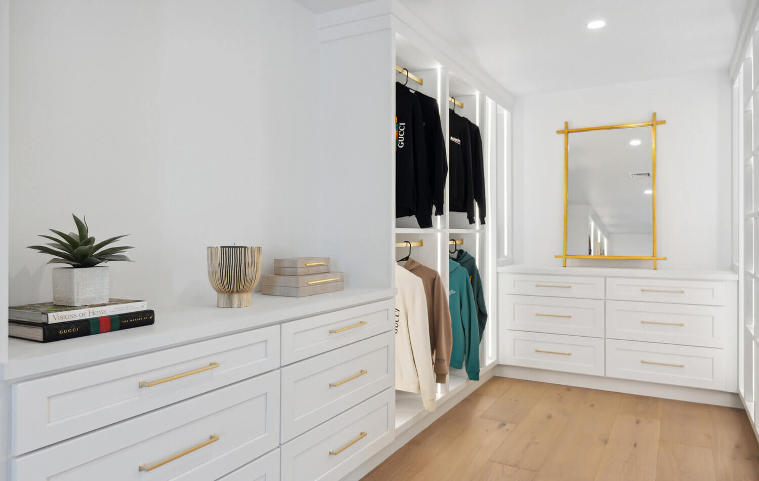A luxury walk-in closet off the master bedroom with his and her storage. There are two layers of hanging rod storage, built-in dressers and dedicated space for both the husband and wife.