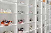 A luxury walk-in closet off the master bedroom with his and her storage. There is a full wall of open cubby storage for displaying shoes with integrated lighting to accent and create a store-like feel to the space.