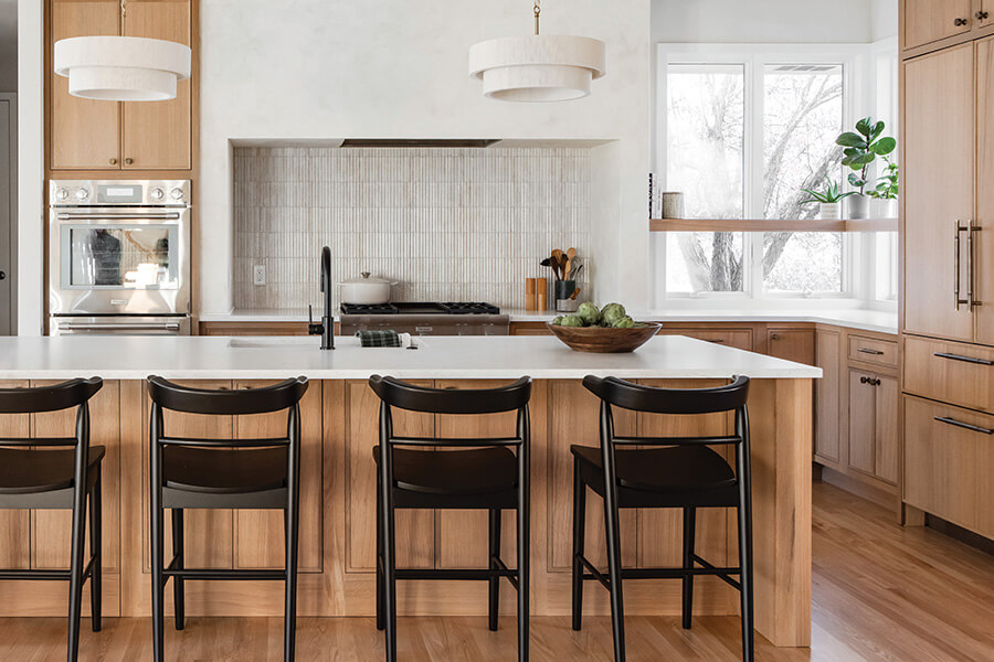 A new kitchen remodel with new light stained quarter-sawn white oak cabinets and a white painted range alcove space with floating shelve crafted by Dutra Supreme.