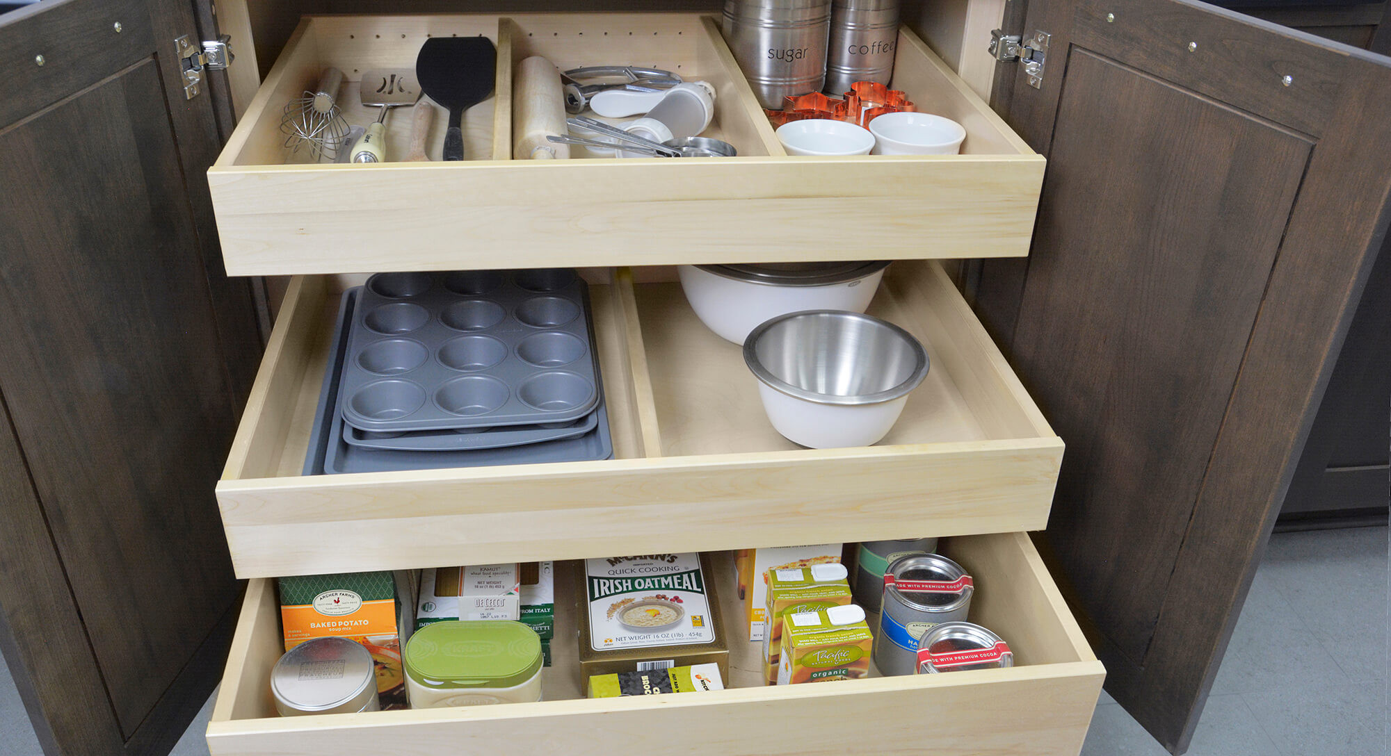 Adjustable Drawer Partitions in Roll-Out Shelf from Dura Supreme Cabinetry showing three roll-out shelves inside one base cabinet.
