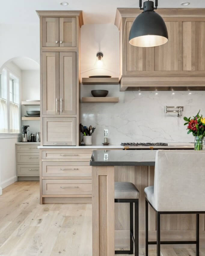 A warm and light stained white oak kitchen with beautiful inset cabinets featuring a minimal shaker style.