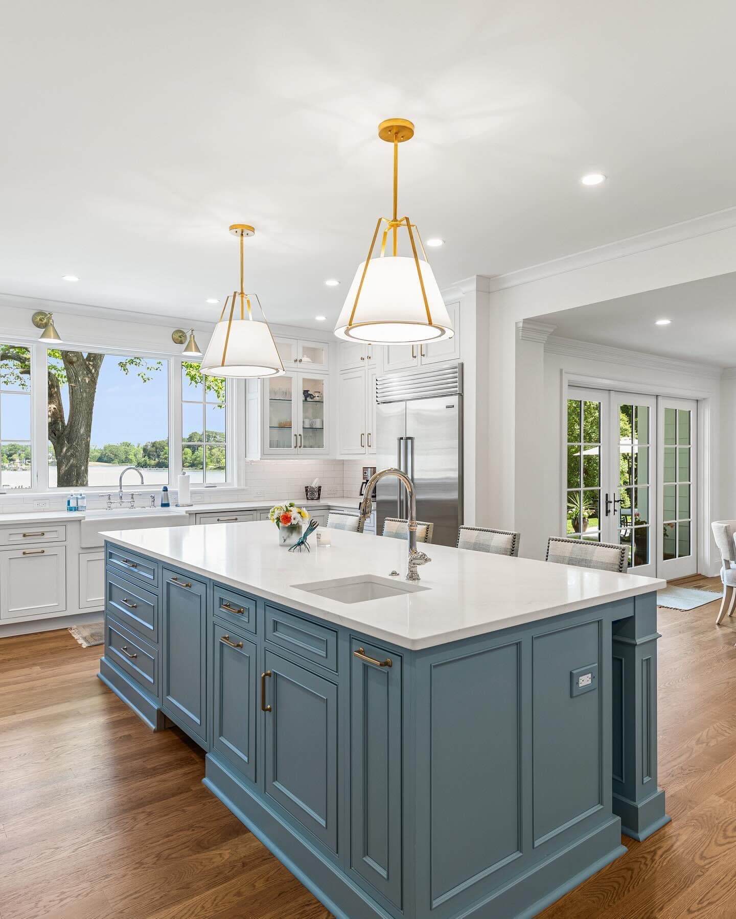 A close up of the gray painted kitchen island styled with inset cabinet doors and a classic furniture-like construction.