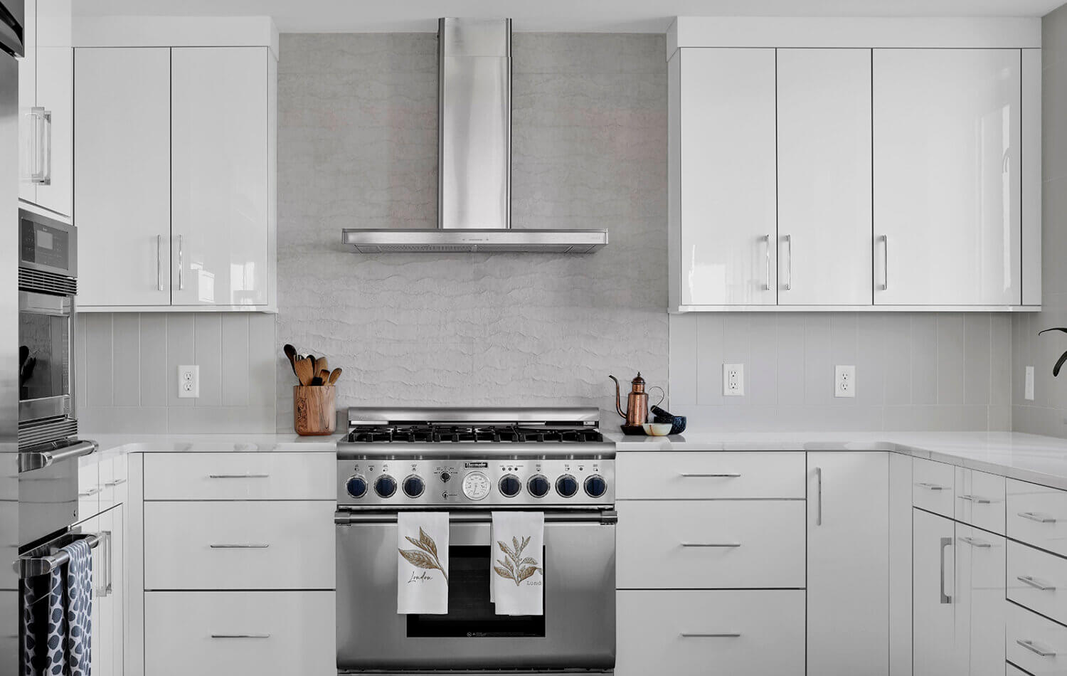 A modern style kitchen with bright, glossy white cabinets and bold black accents.