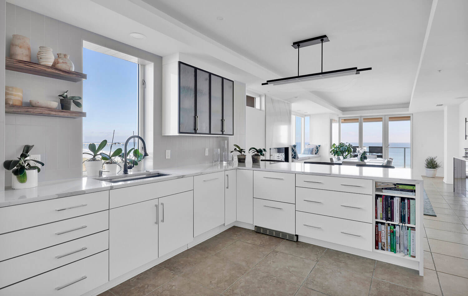 A modern style kitchen with bright, glossy white cabinets and bold black accents.