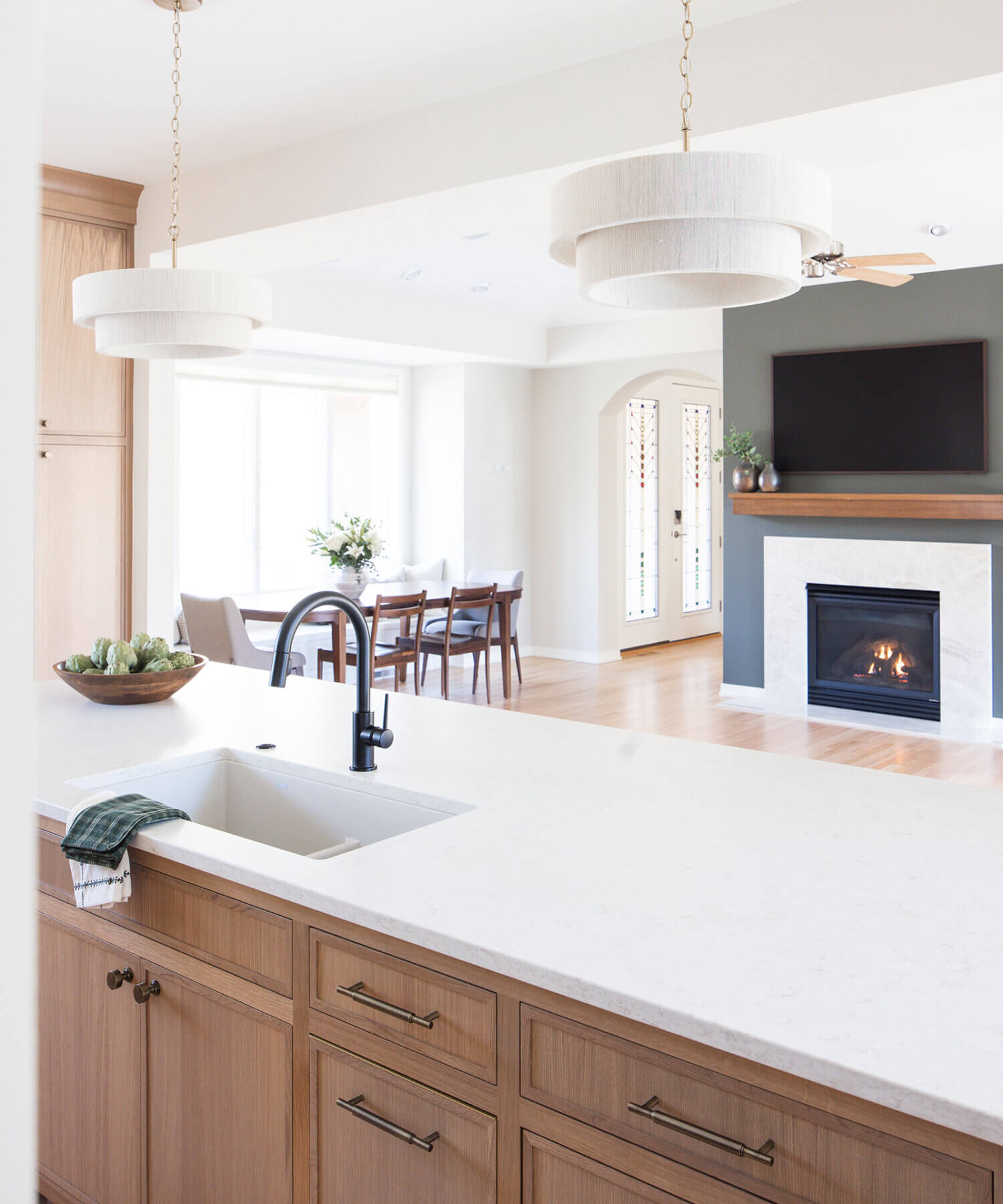 A view over the kitchen island into the dining and living area of this open concept home.