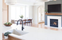 A view over the kitchen island into the dining and living area of this open concept home.