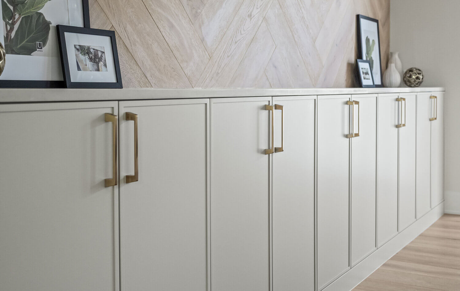 A contemporary dining room with clean lines and skinny shaker cabinets in a natural, off-white paint color. Showing a close up of the cabinets.