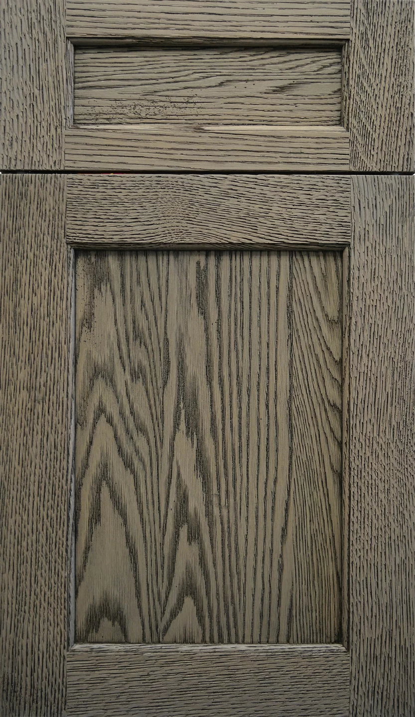 A classic shaker style cabinet door in a weathered oak finish with a medium gray/brown stain color.