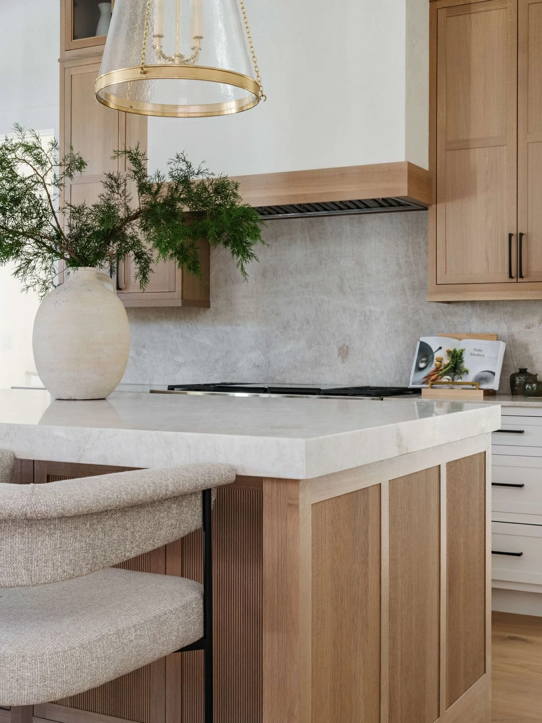 A stunning 2-toned kitchen design with white painted cabinets contrasted by light-stained quarter-sawn white oak cabinets with beautiful reeded accents on the kitchen island.