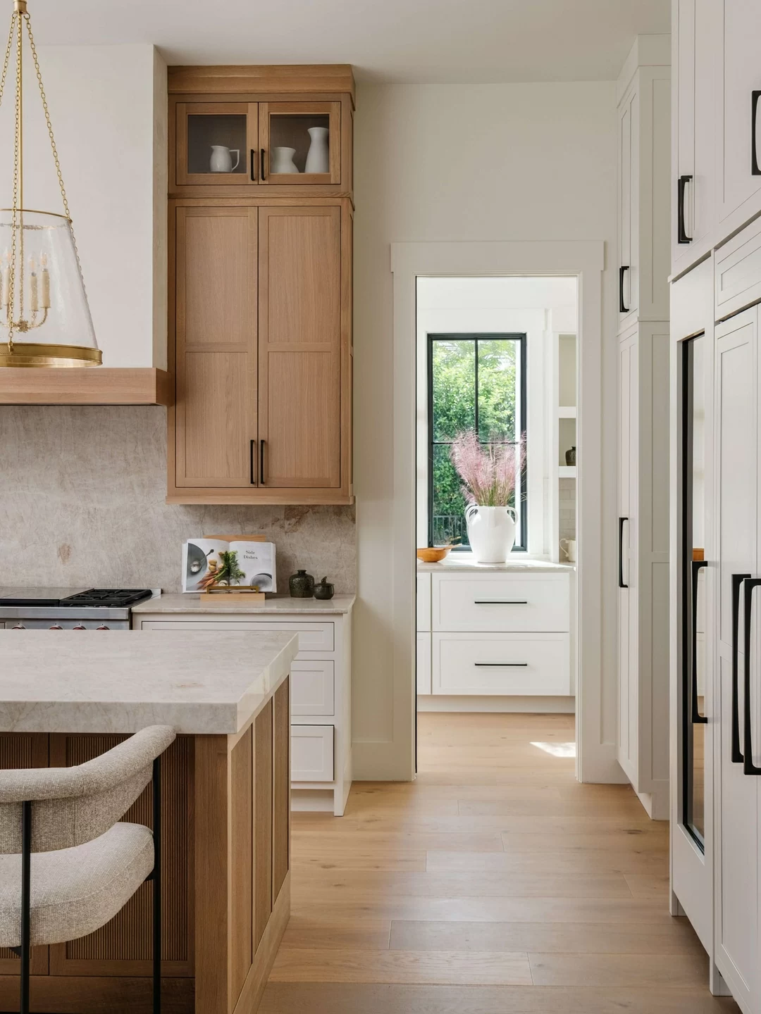 White painted cabinets and blonde stained quarter-sawn white oak cabinets come together in this beautiful kitchen design.