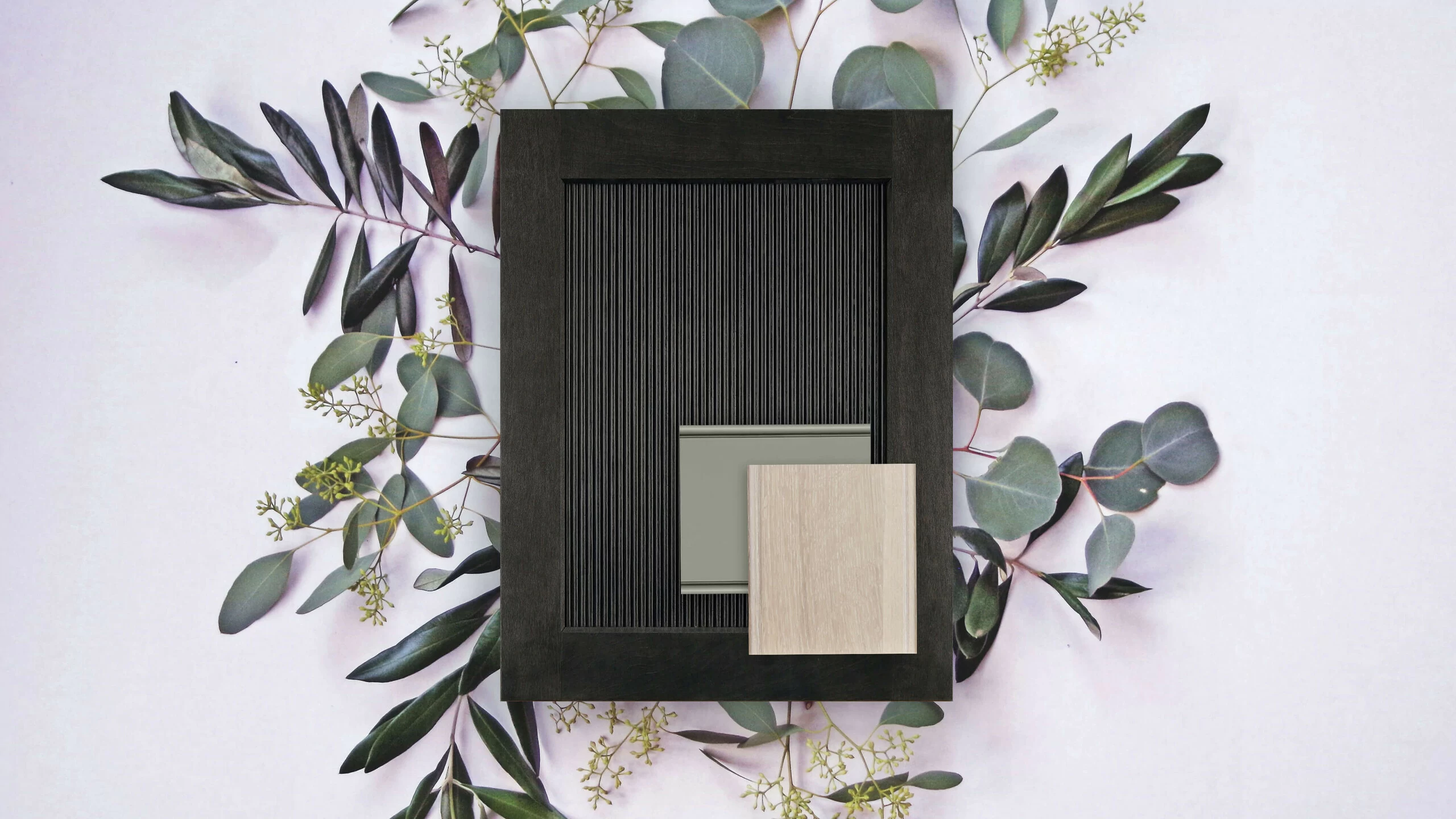 A Biophilic style flat lay showing a reeded cabinet door with a dark stain, a light cerused finish and a sage green finish for selecting cabinetry for a kitchen remodel.